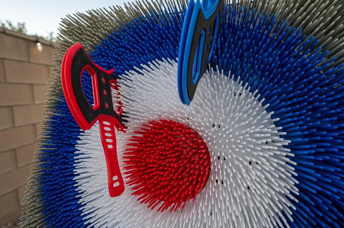 Red and blue throwing axes stuck in a bristle target