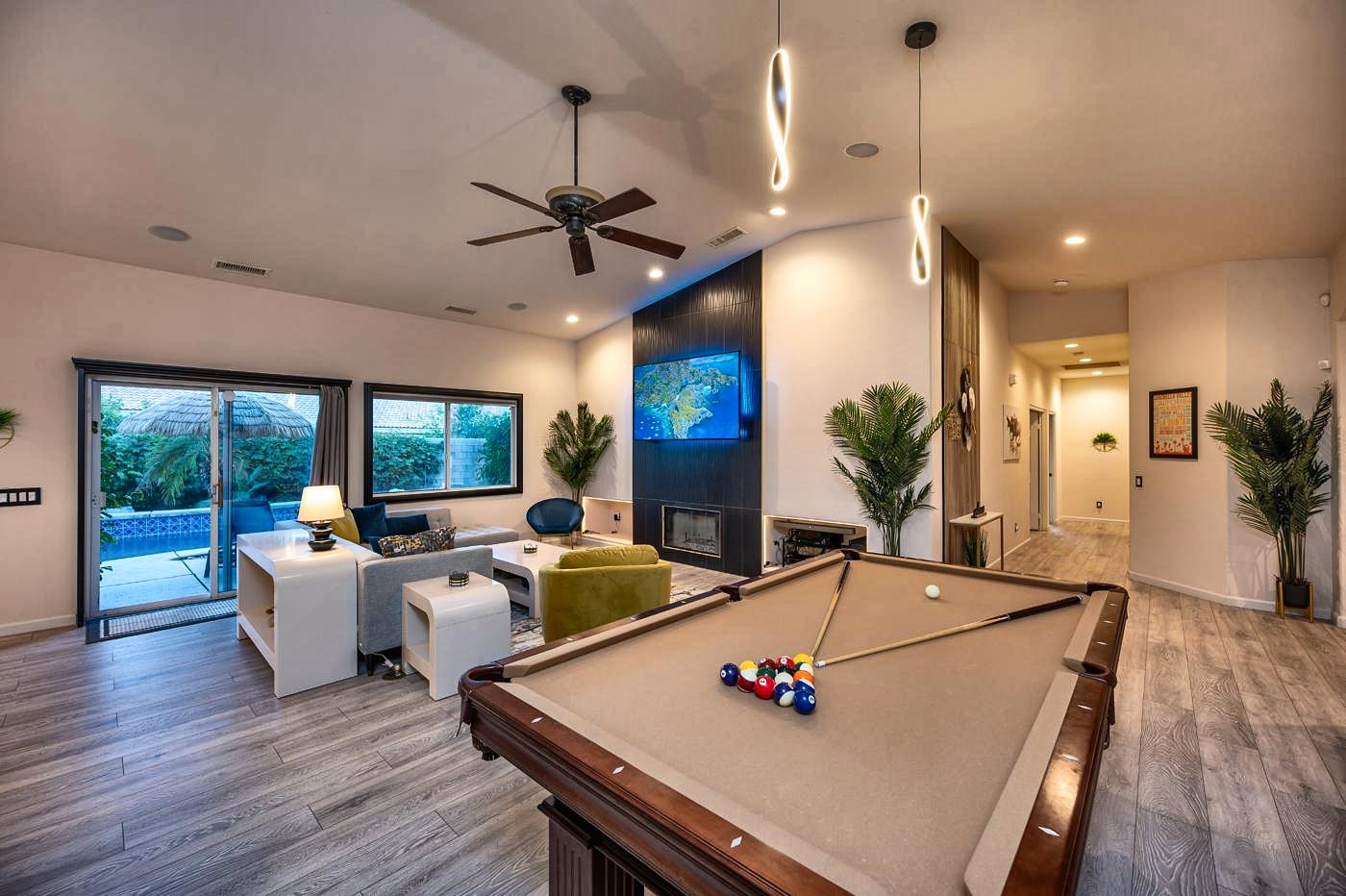 Pool table in daylight with the living room and patio doors behind