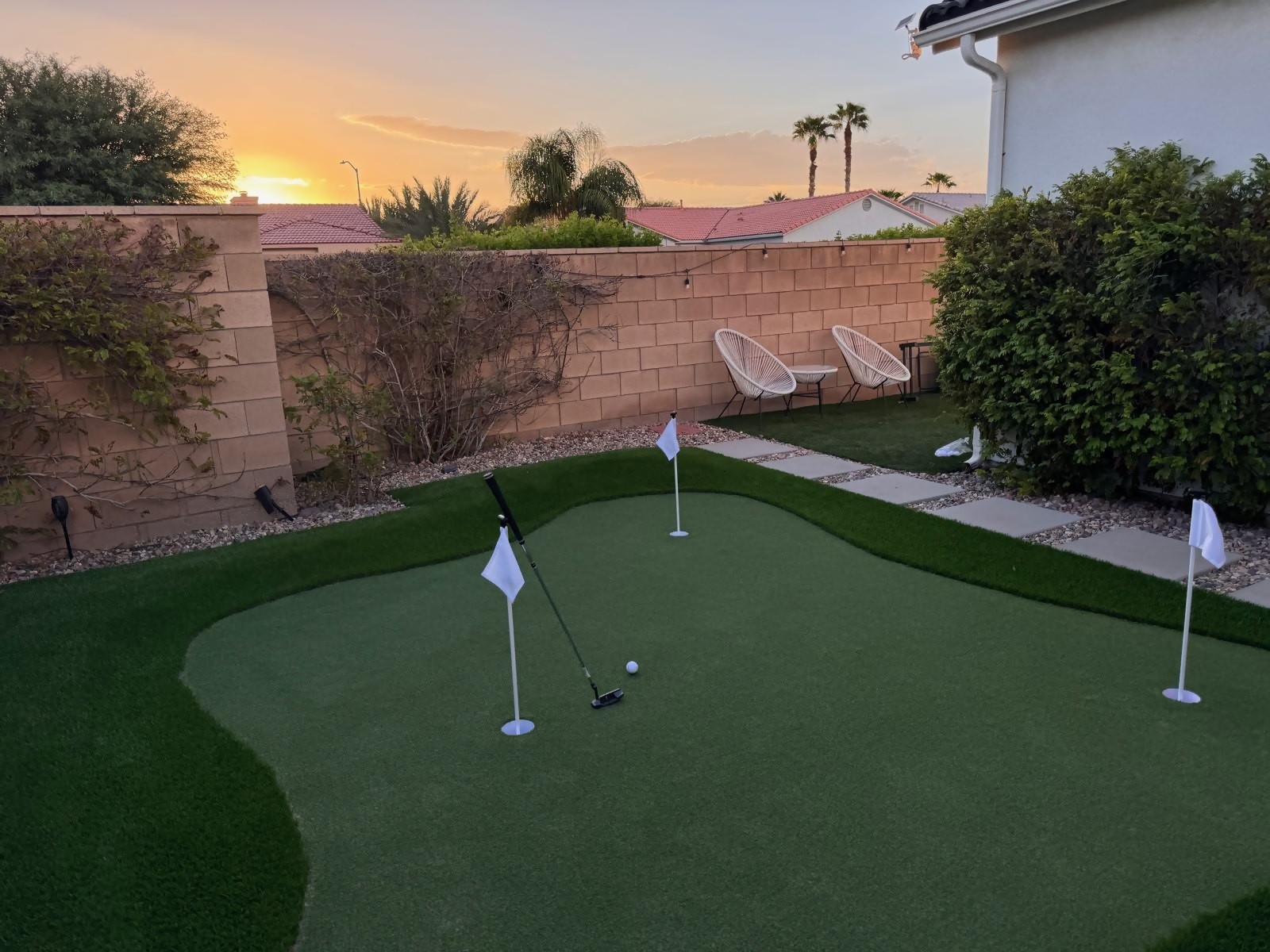 Putter and ball on the green at golden hour