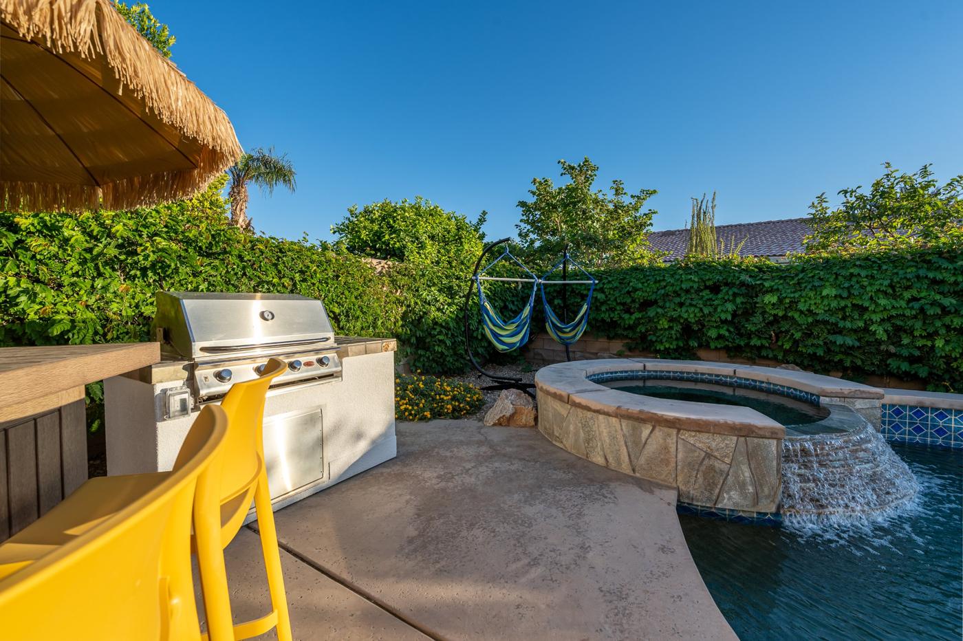 Built-in grill and bar stools beside the spa waterfall