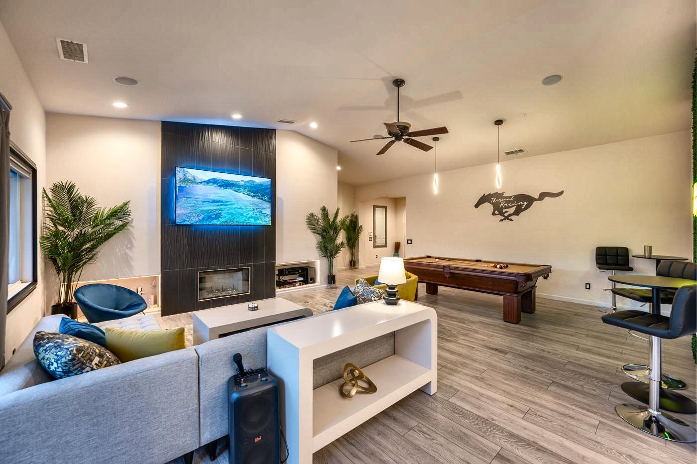 Living room with sectional, fireplace, 80-inch TV and pool table